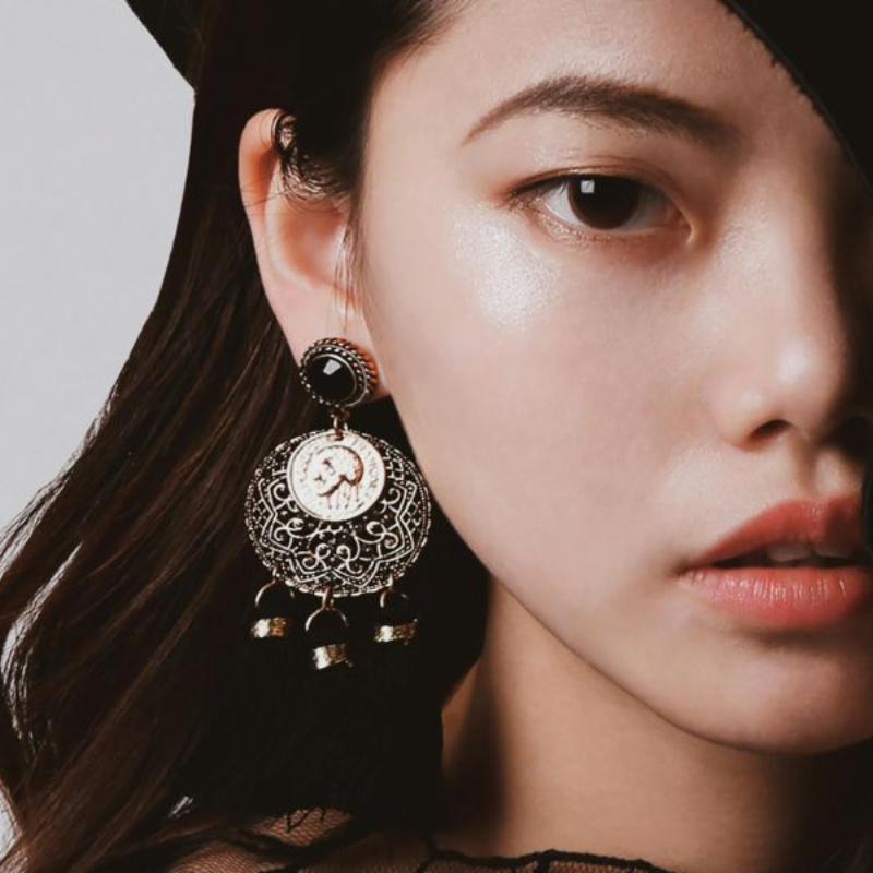 Femme portant des boucles d'oreilles élégantes et grandes.