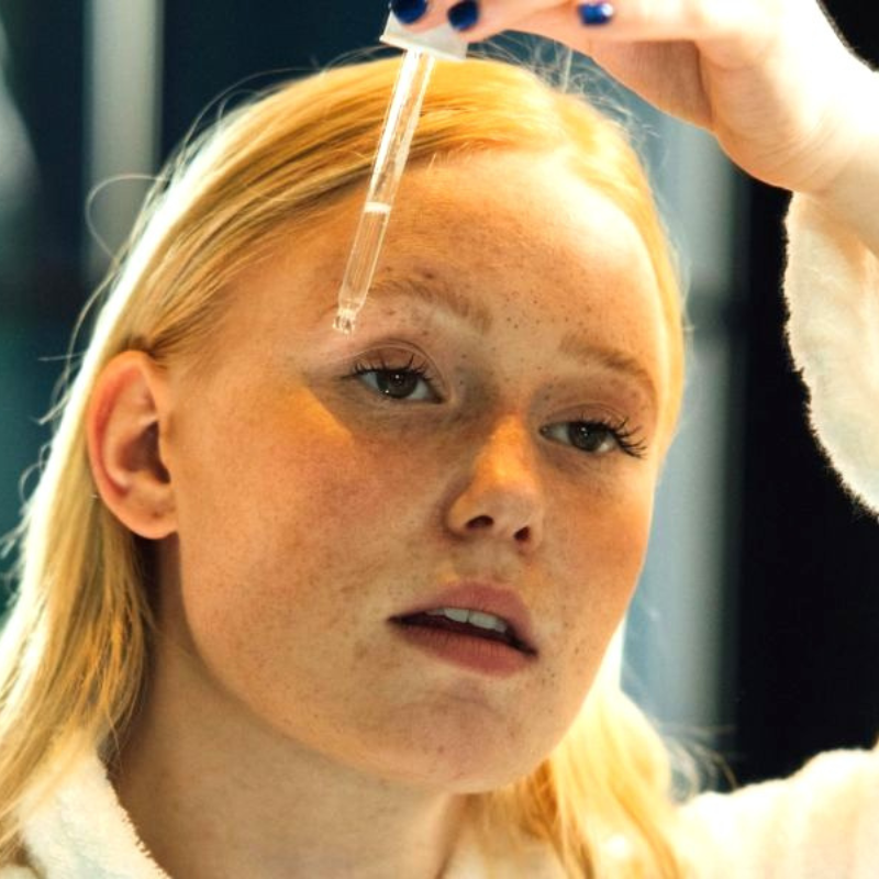 Femme appliquant un sérum sur le visage.