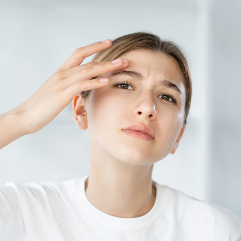 Femme préoccupée touchant son front.