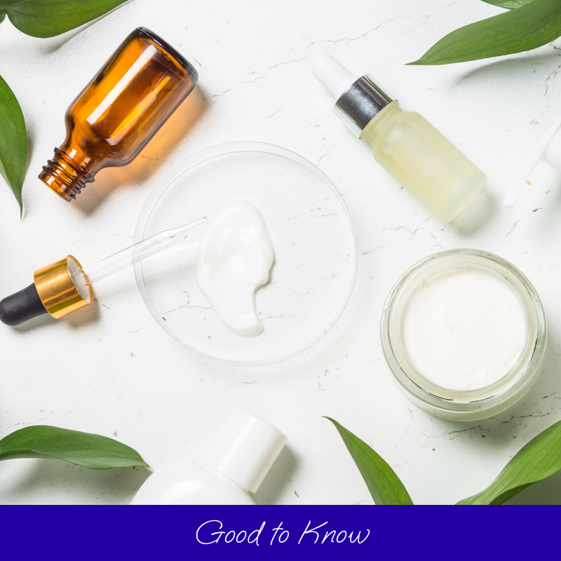 Produits de soin sur fond blanc avec feuilles vertes.