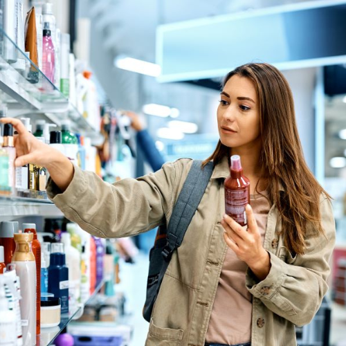 Femme choisissant des produits de beauté en magasin.