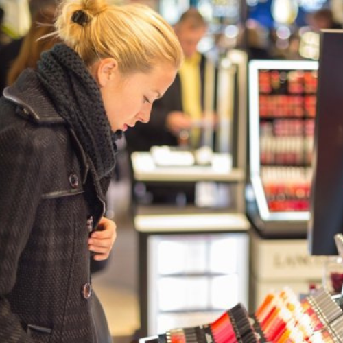 Femme examinant cosmétiques dans un magasin.