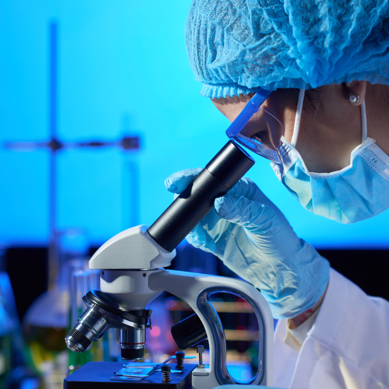 Scientifique observant au microscope en laboratoire.