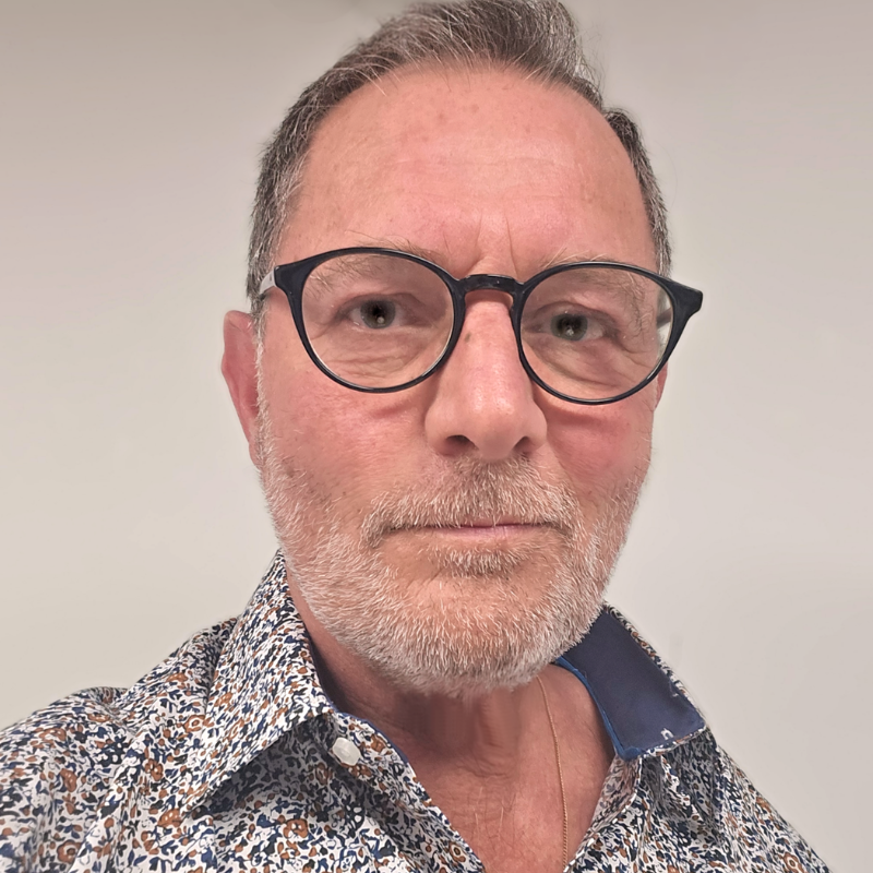 Homme portant des lunettes et une chemise colorée.