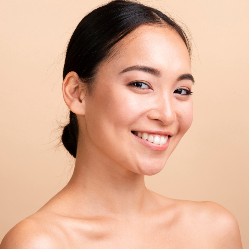 Femme souriante posant sur fond beige