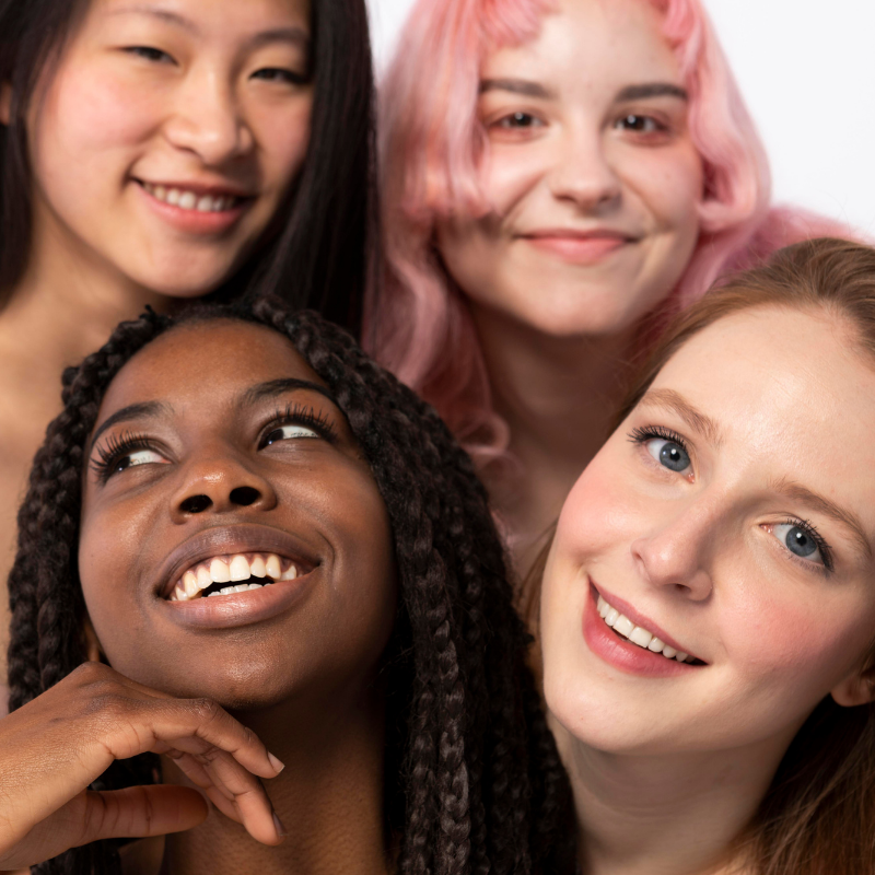 Quatre femmes souriantes ensemble.