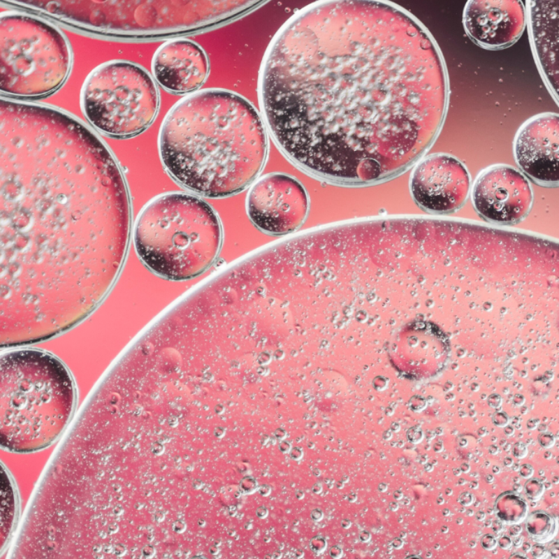 Bulles d'huile rose flottant sur l'eau.