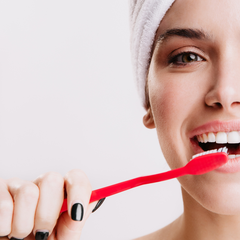 Femme souriante se brosse les dents