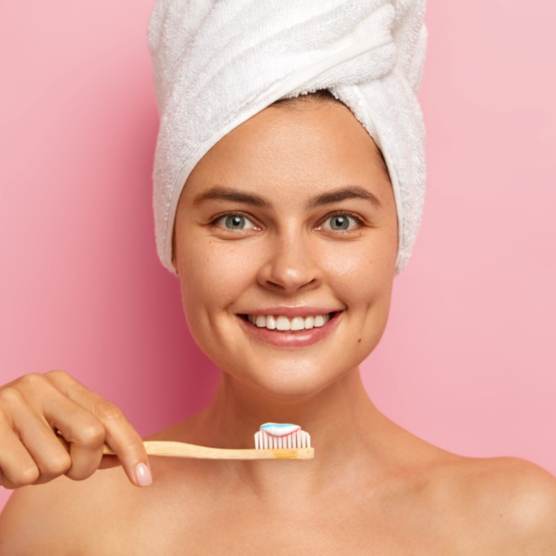Femme souriante avec une brosse à dents.