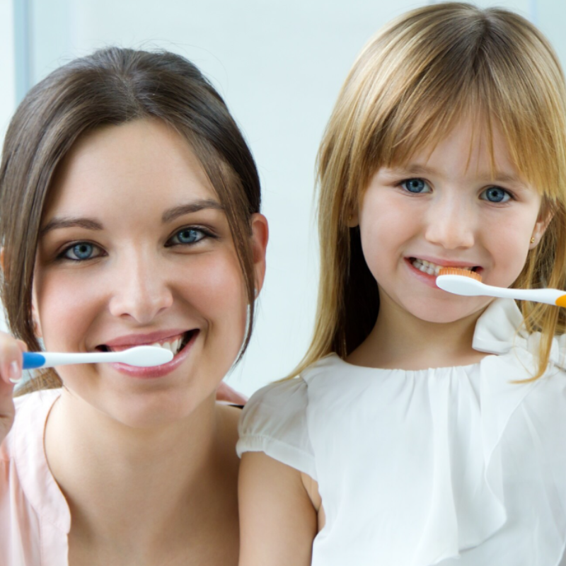 Femme et fille se brossent les dents ensemble.