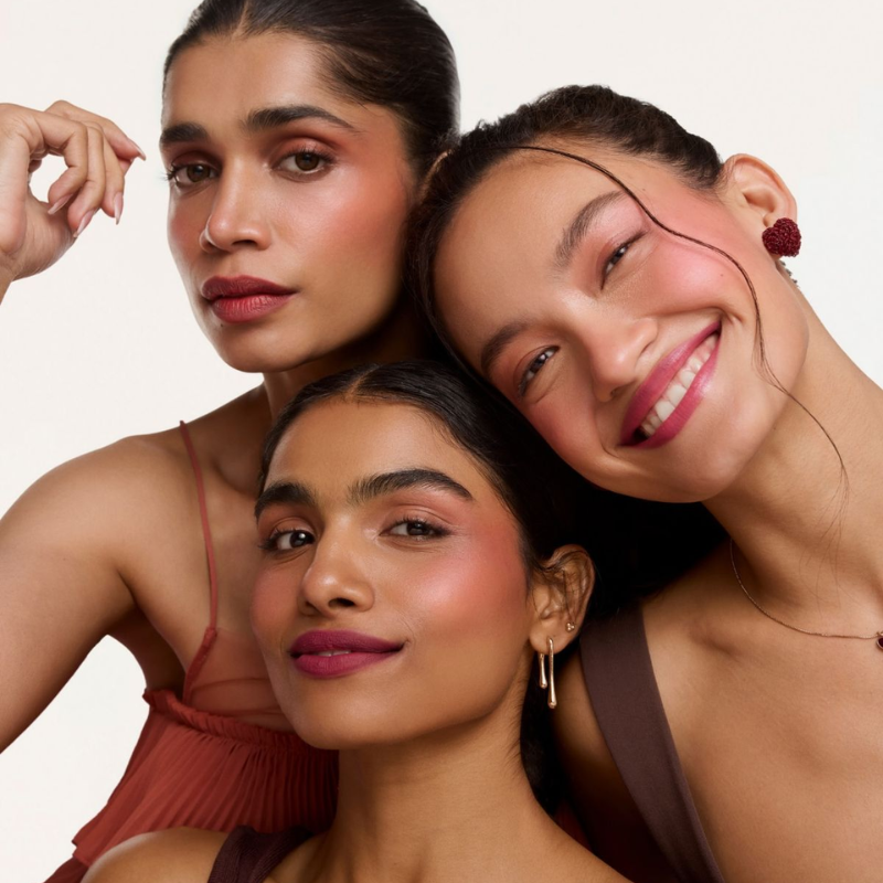 Trois femmes souriantes posant pour une photo.